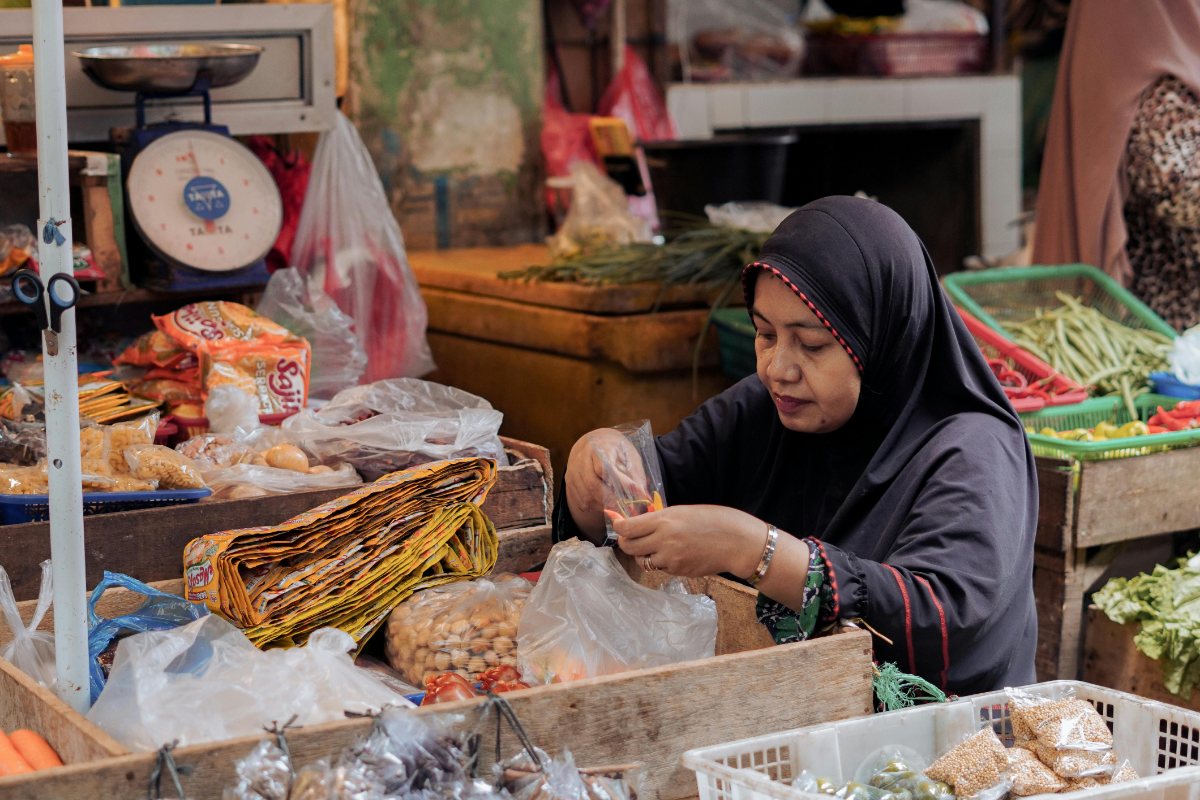 Ilustrasi aktivitas penjual saat memilah bahan pokok di pasar tradisional.