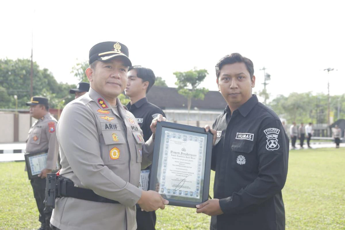 Kapolres Blitar AKBP Arif Fazlurrahman menyerahkan piagam penghargaan kepada anggota berprestasi saat Apel Jam Pimpinan di halaman Mapolres Blitar, Selasa (16/12/2025).